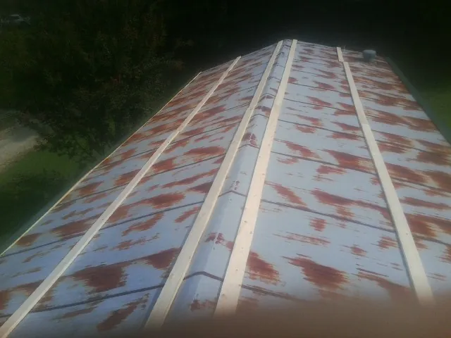Rusted metal roof panels with new wood purlins before replacement — Storm Damage Roof Repair in Walstonburg by Roofing Brothers
