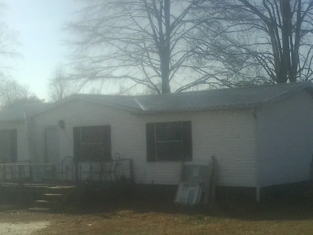 New metal roof on a white painted brick home on a foggy morning in Walstonburg