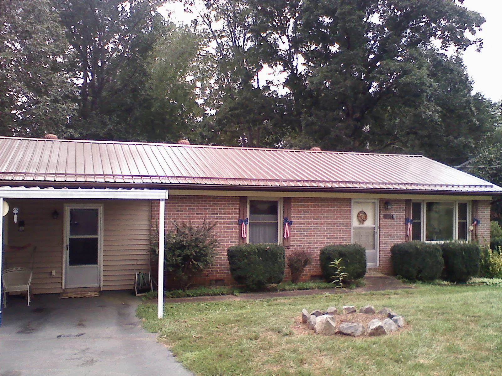 Bronze metal roof and carport on a brick ranch home — Roof Repair work by our crew in Walstonburg